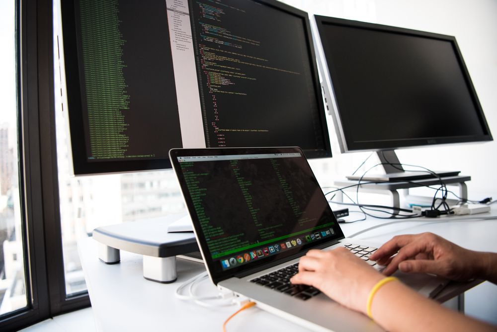 Website development workspace with laptop and desktop screens